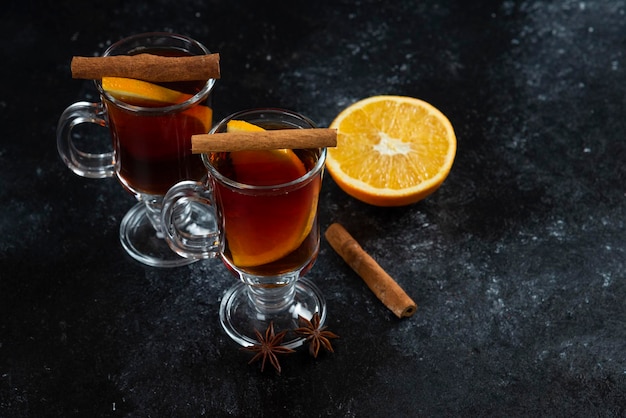 Two glass cups with tea and cinnamon sticks.