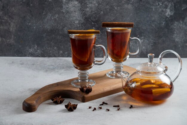 Two glass cups with tea and cinnamon sticks.