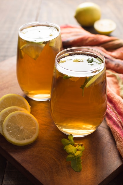 Free photo two glass of lemon and ginger herbal tea on wooden table