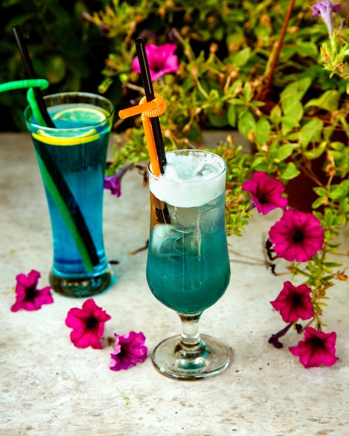 Два стакана синих напитков с пластиковыми трубочками