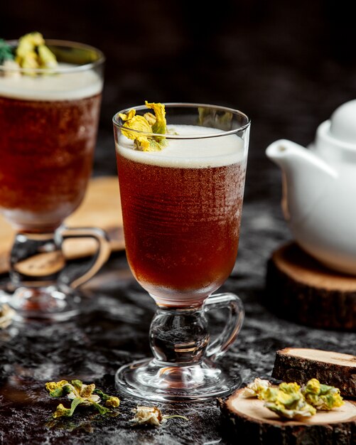 Two glasses of cold cocktail garnished with dried flowers