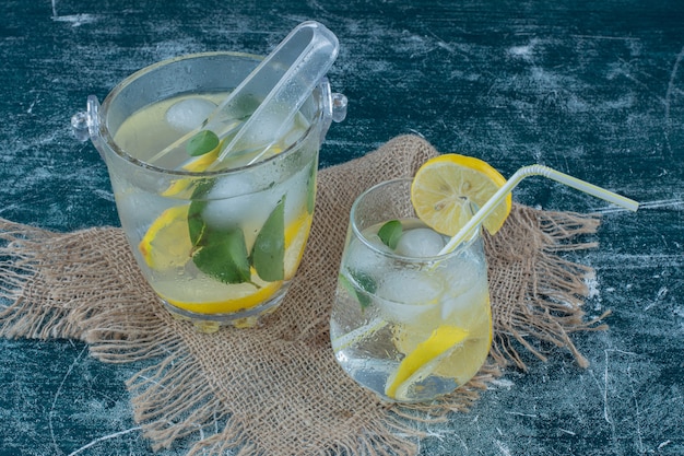 Two glasses of Ice lemon drink on the towel, on the blue background. High quality photo