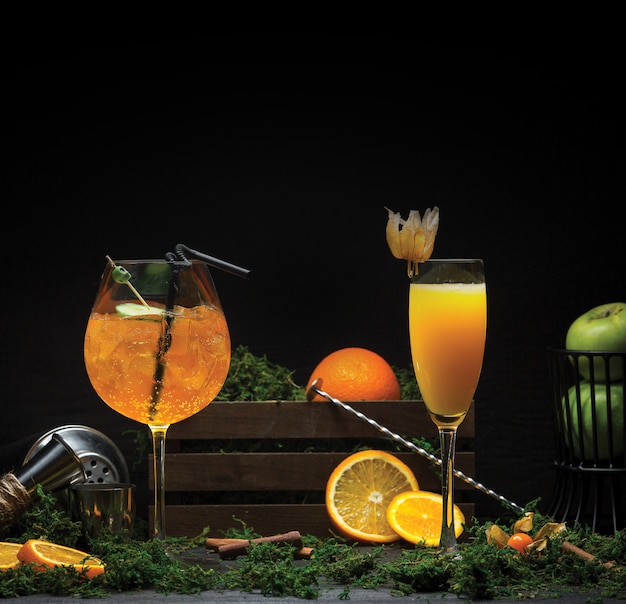 Two glasses of orange juices with and without ice cubes.