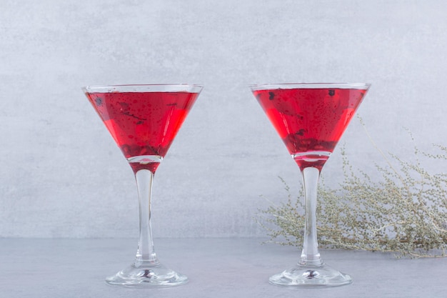 Два стакана красного сока на каменном фоне. Фото высокого качества