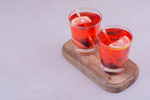 Free photo two glasses of red juice on a wooden board