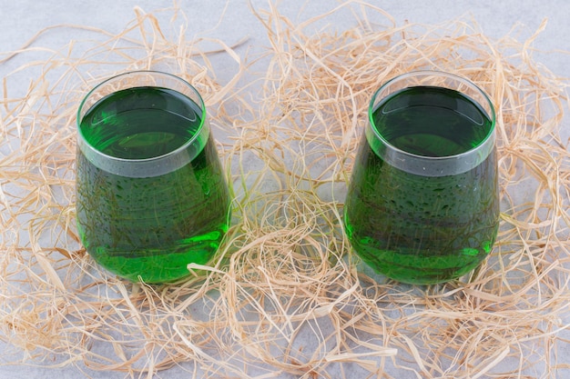 Free photo two glasses of tarragon juice on marble background. high quality photo