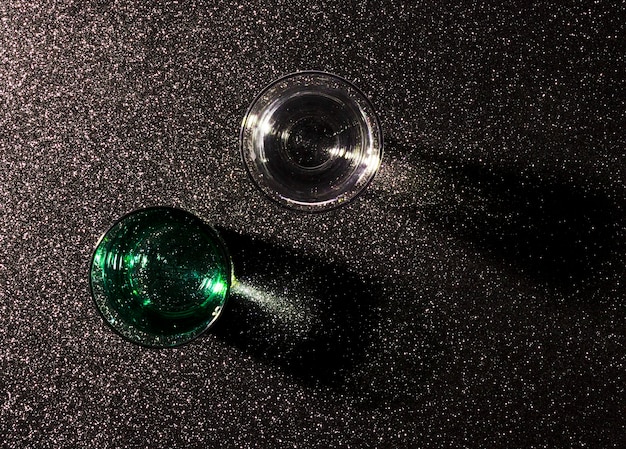 Two glasses of water on shiny black background