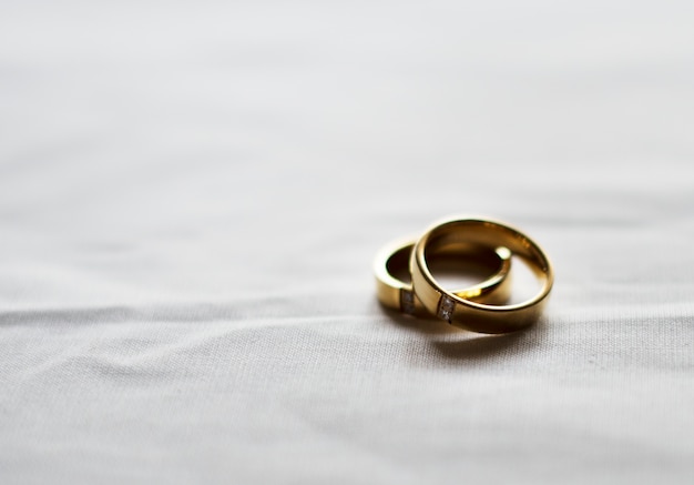 Foto gratuita una fede nuziale di due oro su fondo bianco