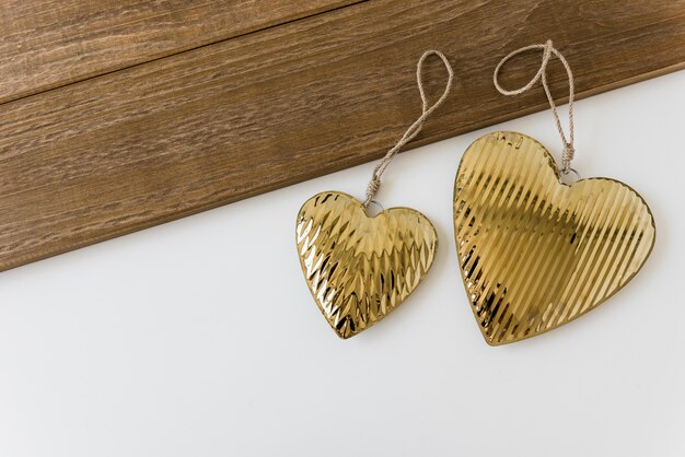 Две золотые формы сердца на белом фоне