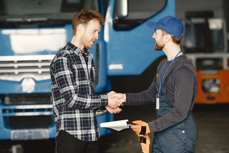 Two guys talking about work. Work in garage near truck. Transfer of documents with goods
