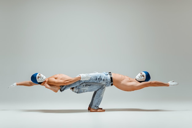 Due uomini caucasici acrobatici relativi alla ginnastica sulla posa dell'equilibrio