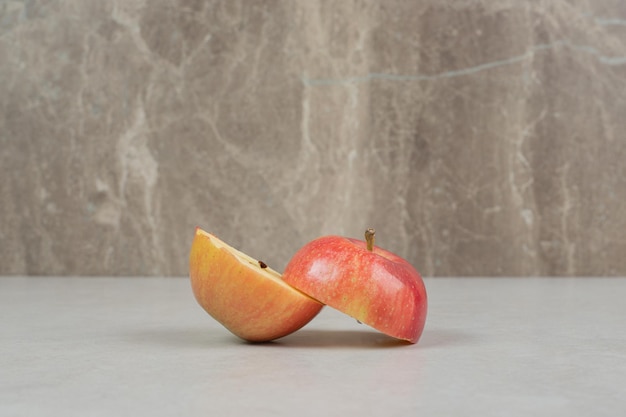 Two half cut red apples on gray table