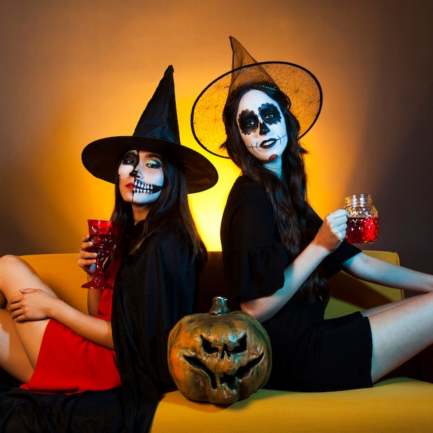 Foto gratuita due ragazze di halloween sul divano