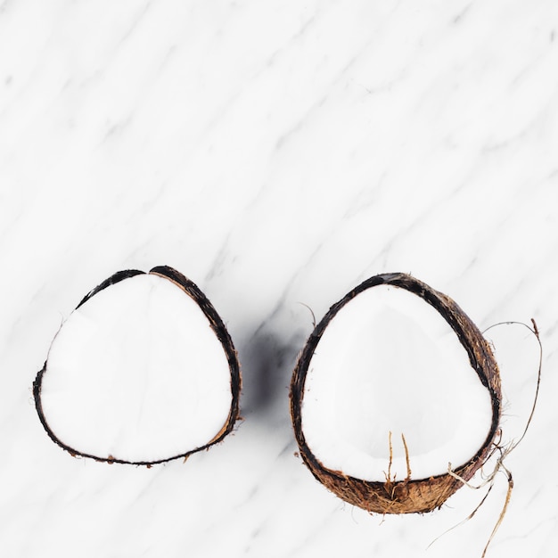 흰색 대리석 백그라운드에 잘 익은 코코넛의 두 반쪽