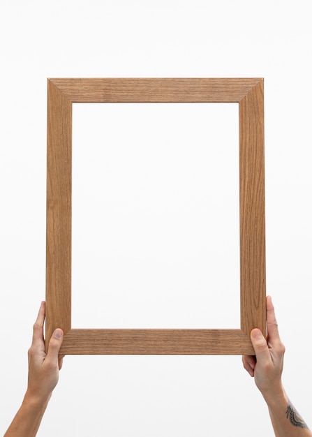 Free photo two hands holding big wooden frame