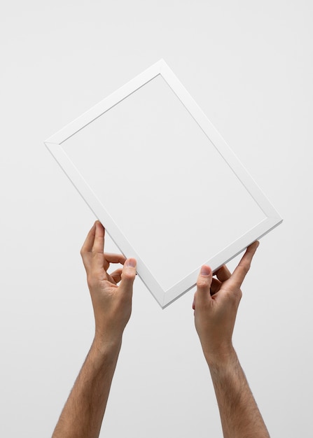 Two hands holding white frame front view
