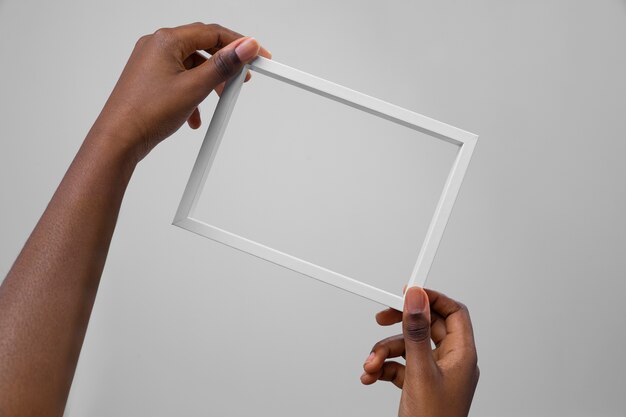 Two hands holding white frame
