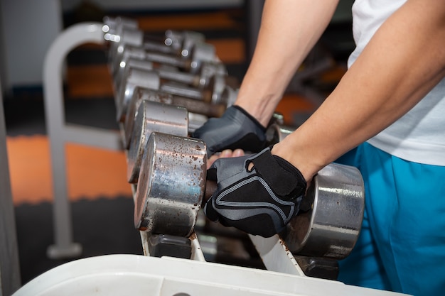 Two hands picking up old weight dumbbell for exercise