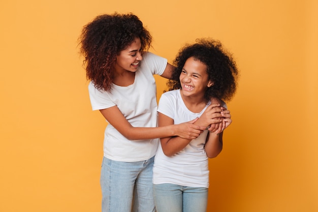 Two happy afro american sisters having fun while standing