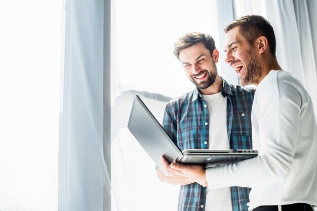 Two happy businessman working on laptop