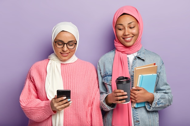 Free photo two happy muslim students have coffee break