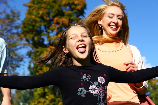 Two happy sisters have fun in park