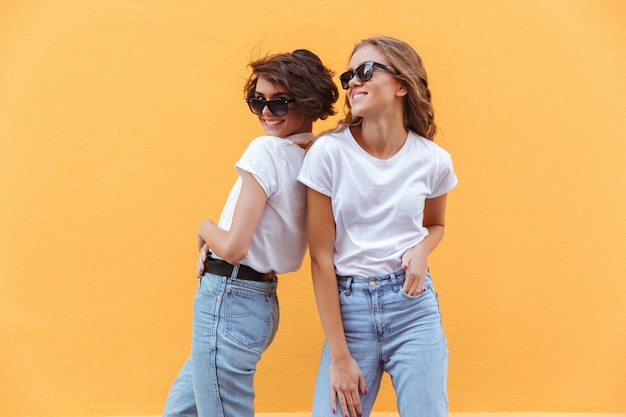 Two happy smiling teenage girls in sunglasses posing