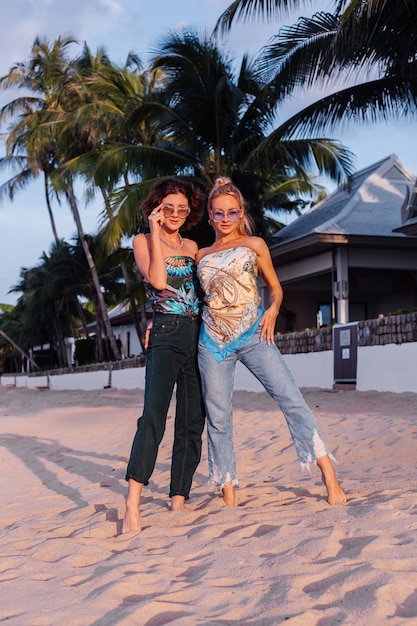 熱帯の国での休暇中にサングラスをかけた2人の幸せな女性の友人