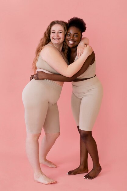 Two happy women posing while wearing a body shaper