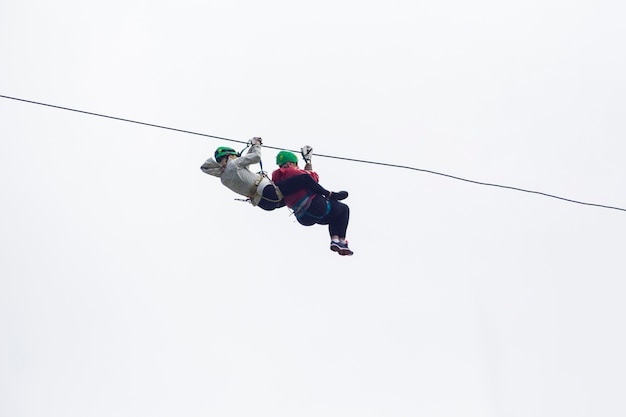 Free photo two hiker on zip line adventure against sky at costa rica