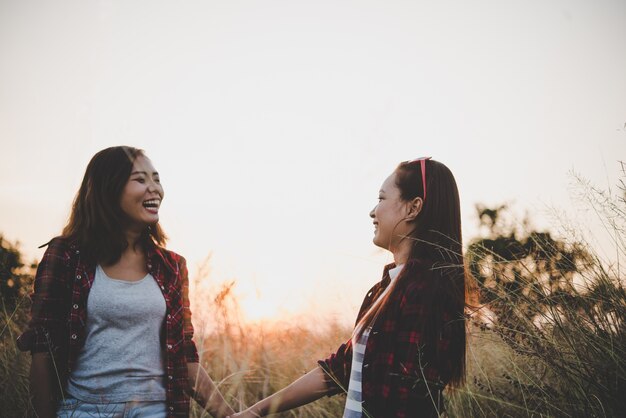 Two hipster teenage girlfriends having fun in field. Women lifestyle concept.