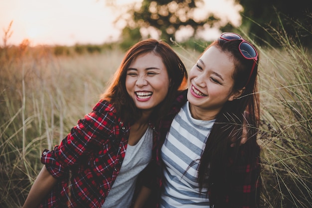 Free photo two hipster teenage girlfriends having fun in field. women lifestyle concept.