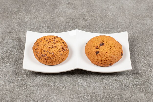 Two homemade fresh cookie on white plate.