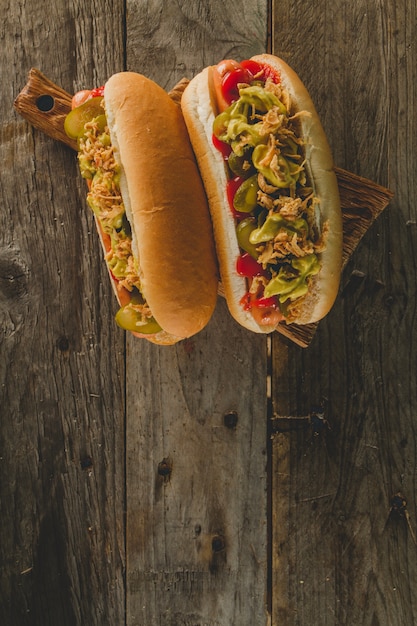 Two hot dogs on wooden surface