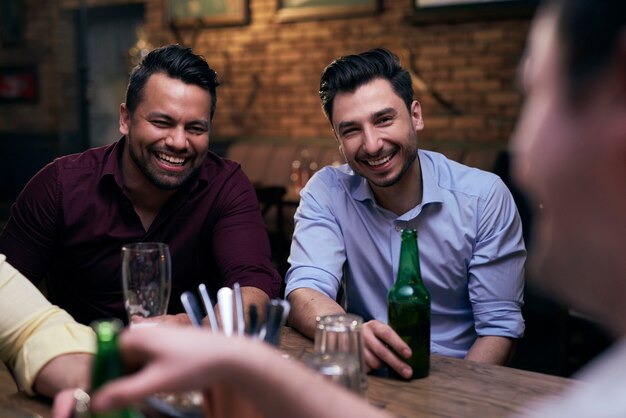 Two joyful men spending time in the pub