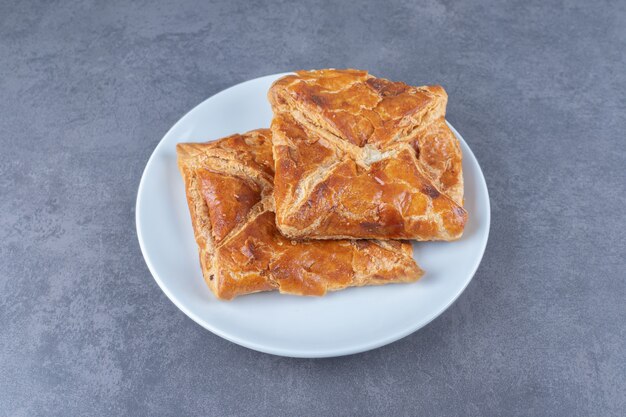 Two khachapuri layered on a plate , on the marble.