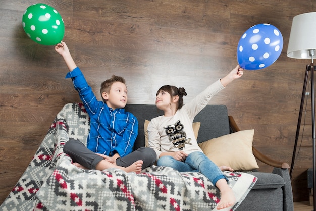 Two kids playing with balloons