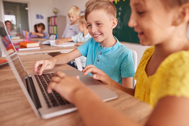 Two kids using laptop during lesson