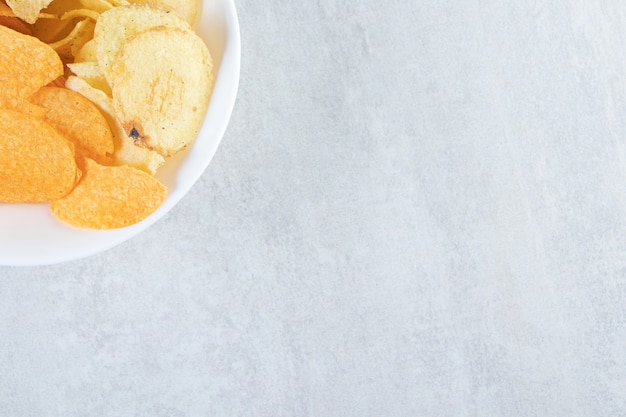 Two kinds of delicious crispy chips on stone.