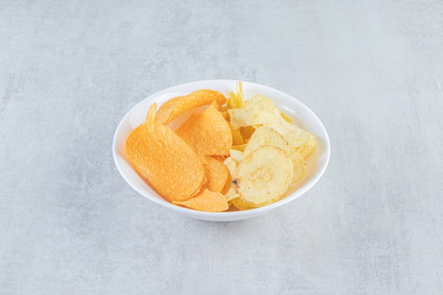 Two kinds of delicious crispy chips on stone.