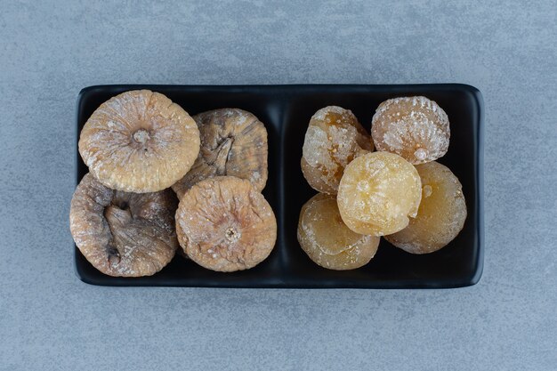 Free photo two kinds of dried fruit in the bowl, on the marble table.