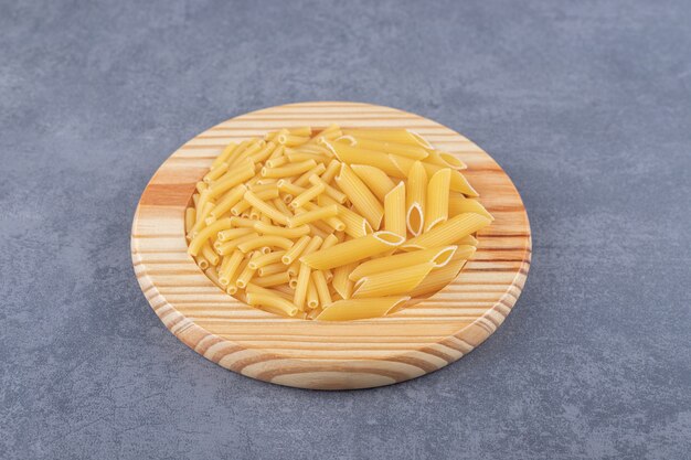 Due tipi di pasta sul piatto di legno.