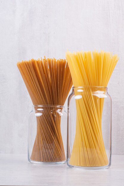 Two kinds of spaghetti inside glass jars