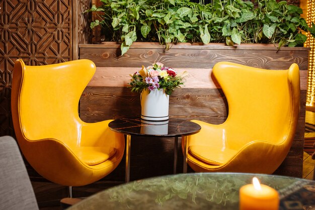 레스토랑에서 두 개의 가죽 노란색 안락 의자와 커피 테이블