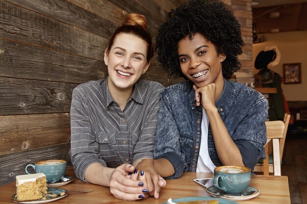 Two lesbians of different races having nice time together at coffee shop