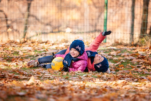 The two little baby girls playing in autumn leaves