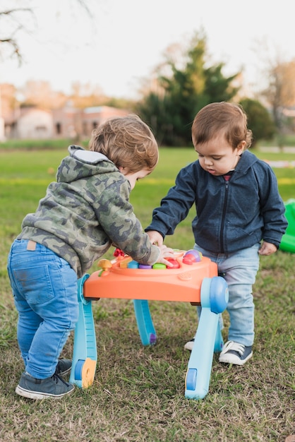 Free photo two little brothers playing with musical toy