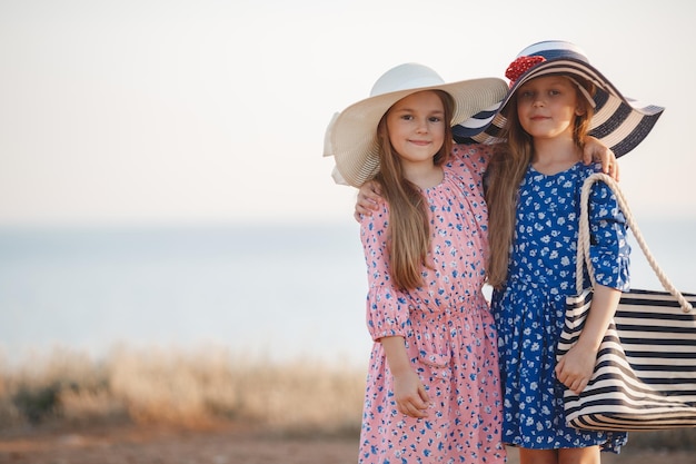 two little girls in dress and hat outdoor