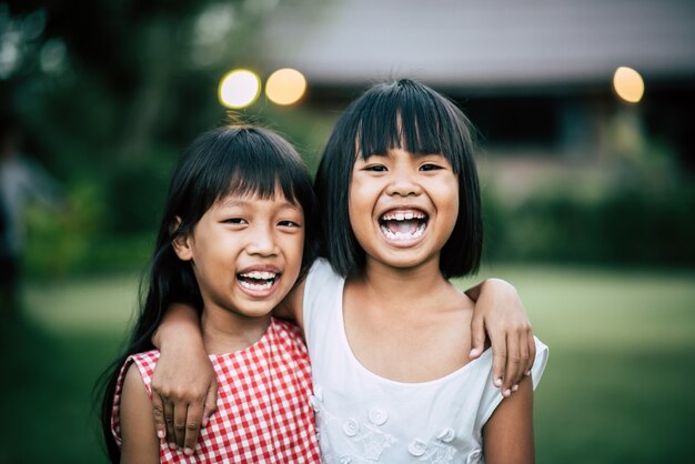 Two little girls friends playing funny in the park