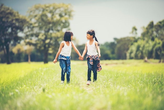 Una mano di due bambine che tiene insieme divertendosi nel parco